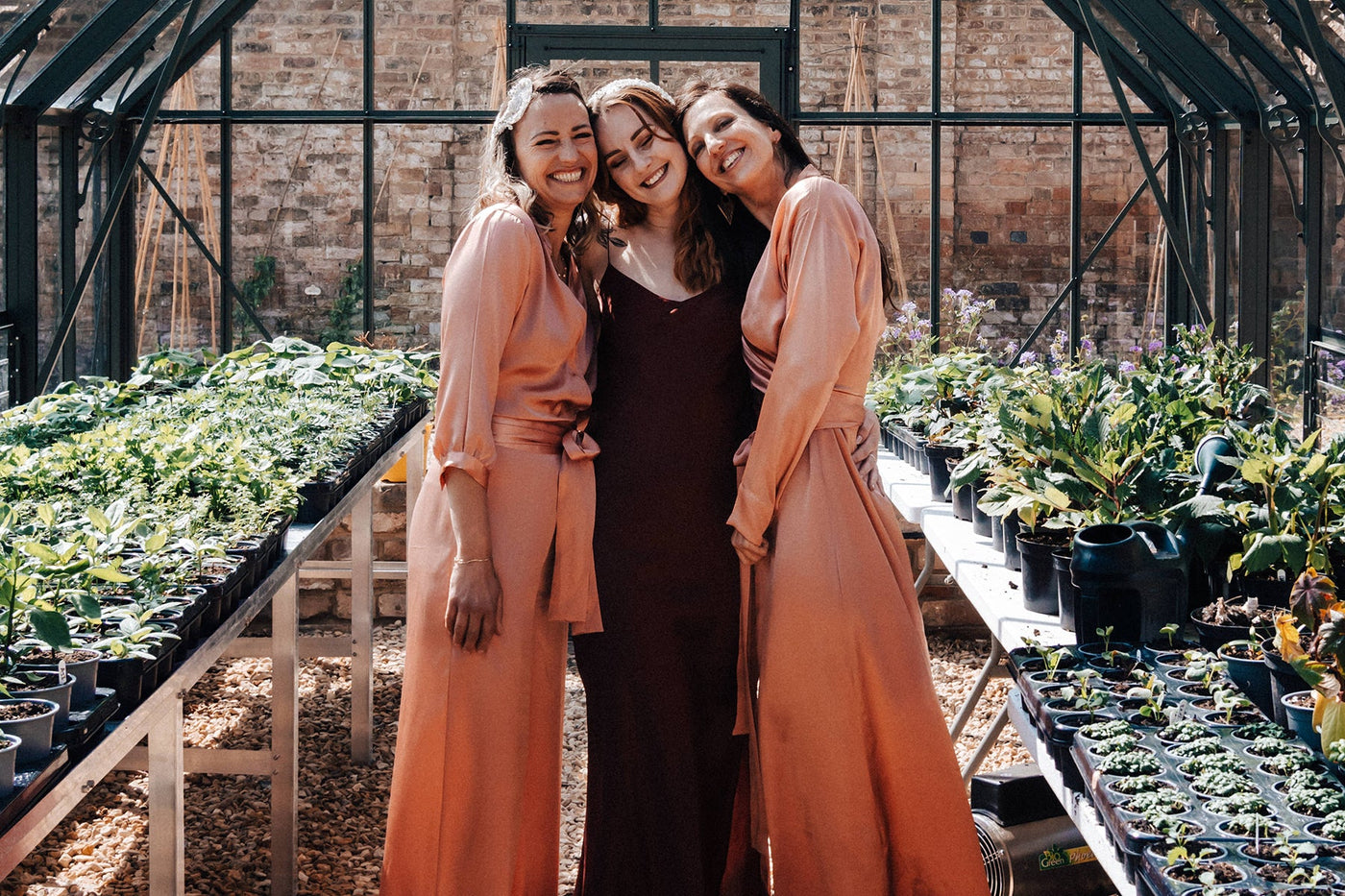 three women in silk outfits including a cherry red silk slipdress