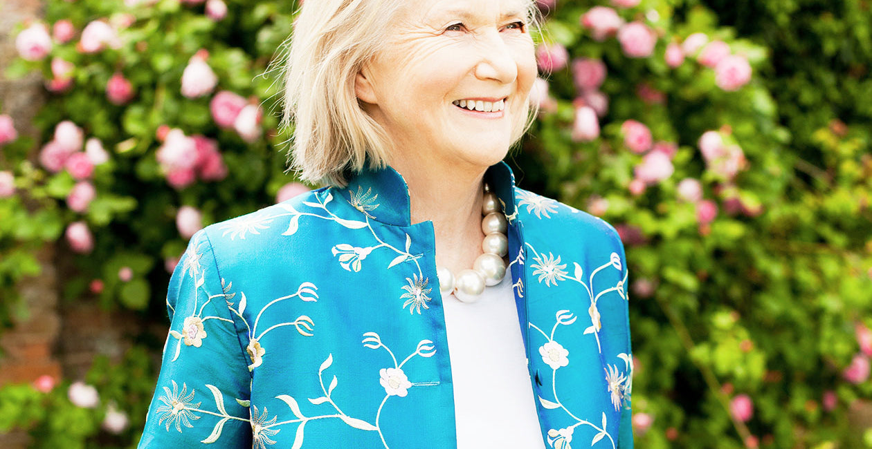 Mature lady in a blue nehru collar silk jacket, a lovely outfit for a mother of the bride or groom. 