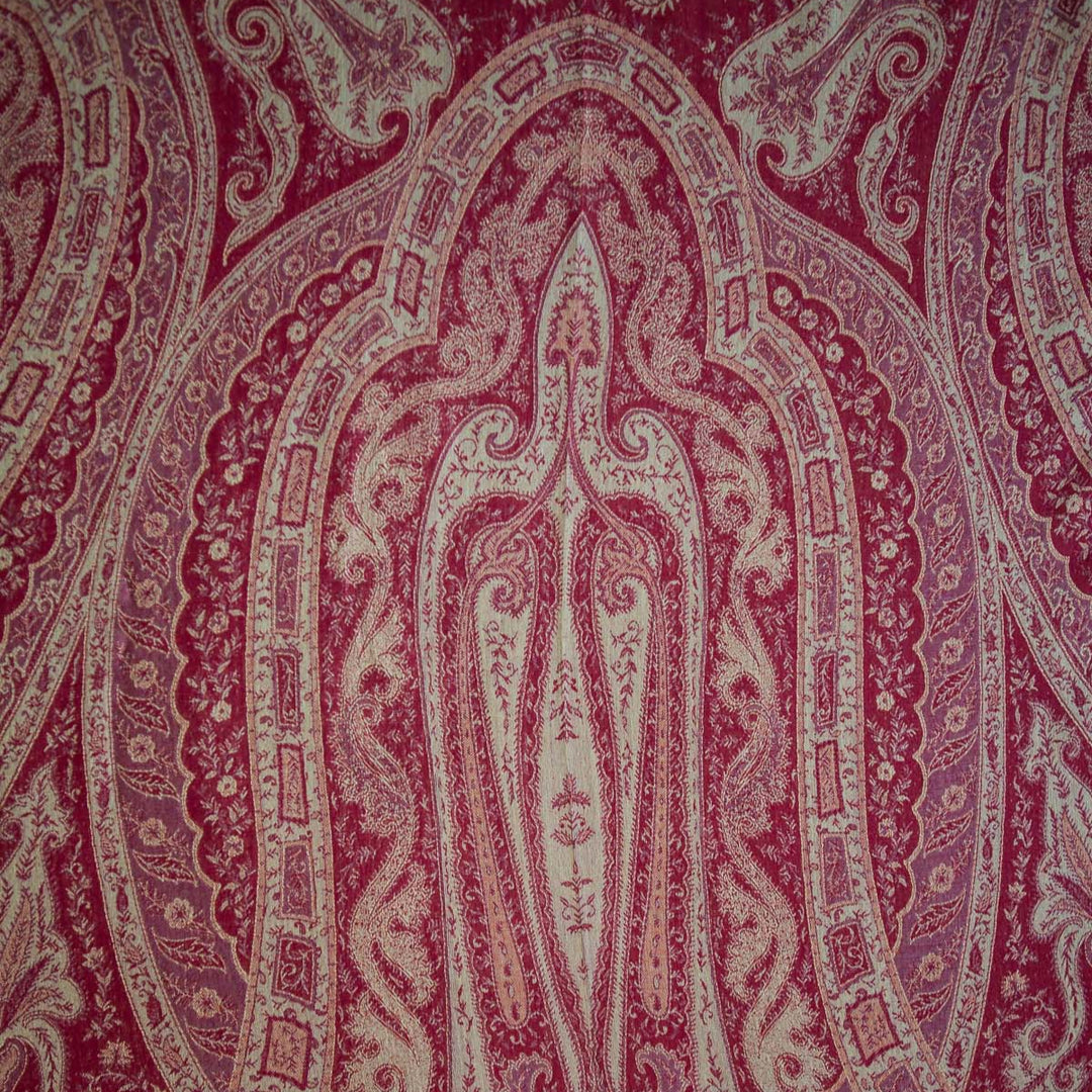 Close-up of a patterned fabric with intricate design in red and beige.