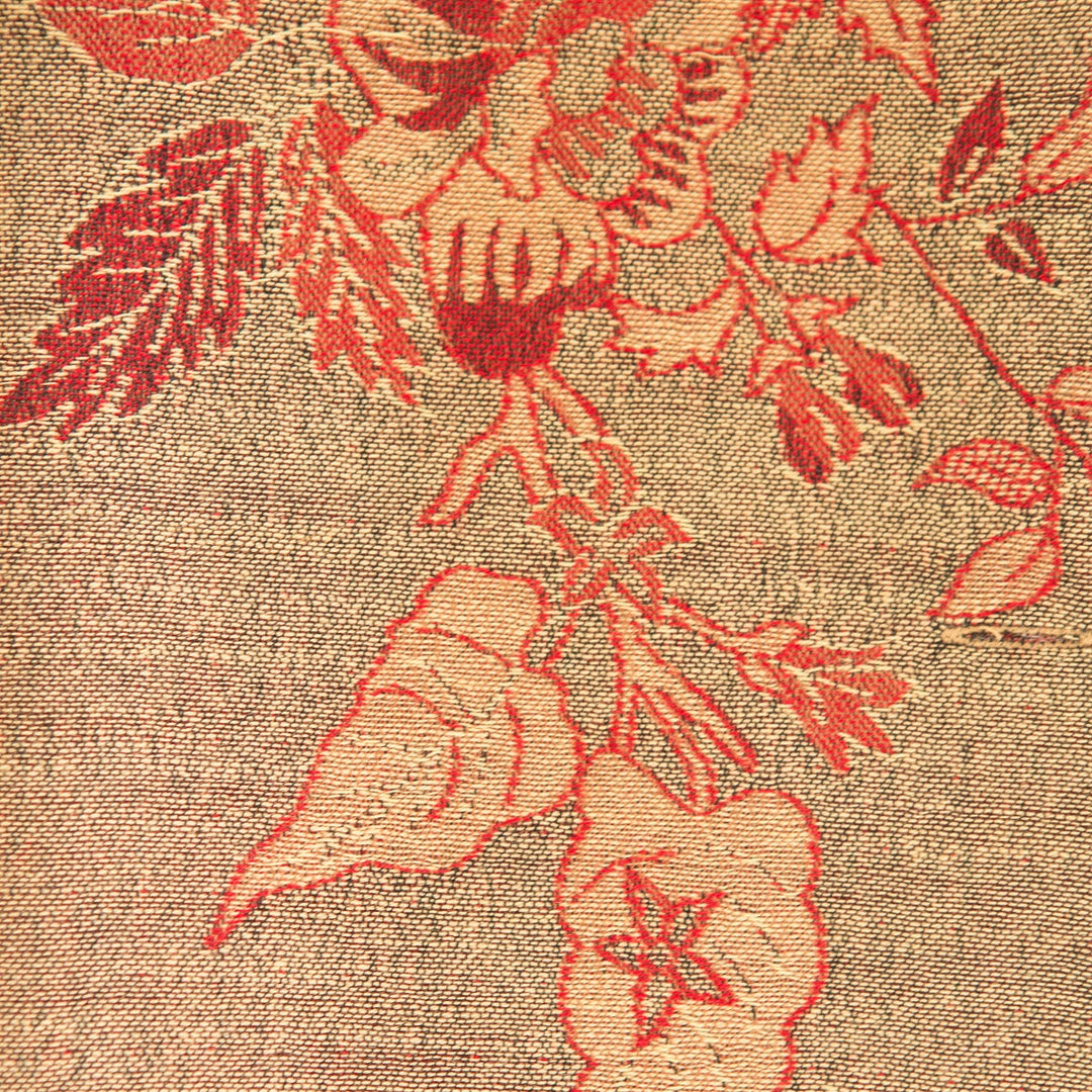 Close-up of floral embroidery on fabric with red thread.