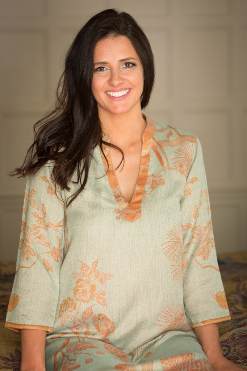 Elegant light green kaftan with orange flowers. Holiday outfit.