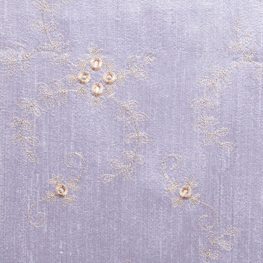 Silk lilac fabric with golden embroidered flowers.