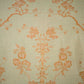 Fabric with floral and bird pattern in orange on a beige background
