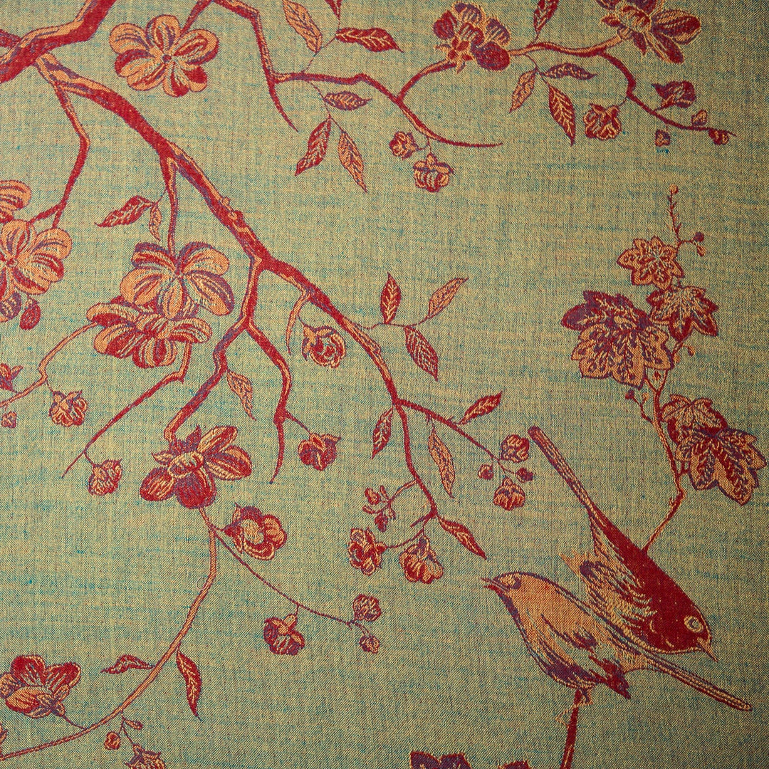 Decorative fabric with red floral and bird pattern on a textured green background