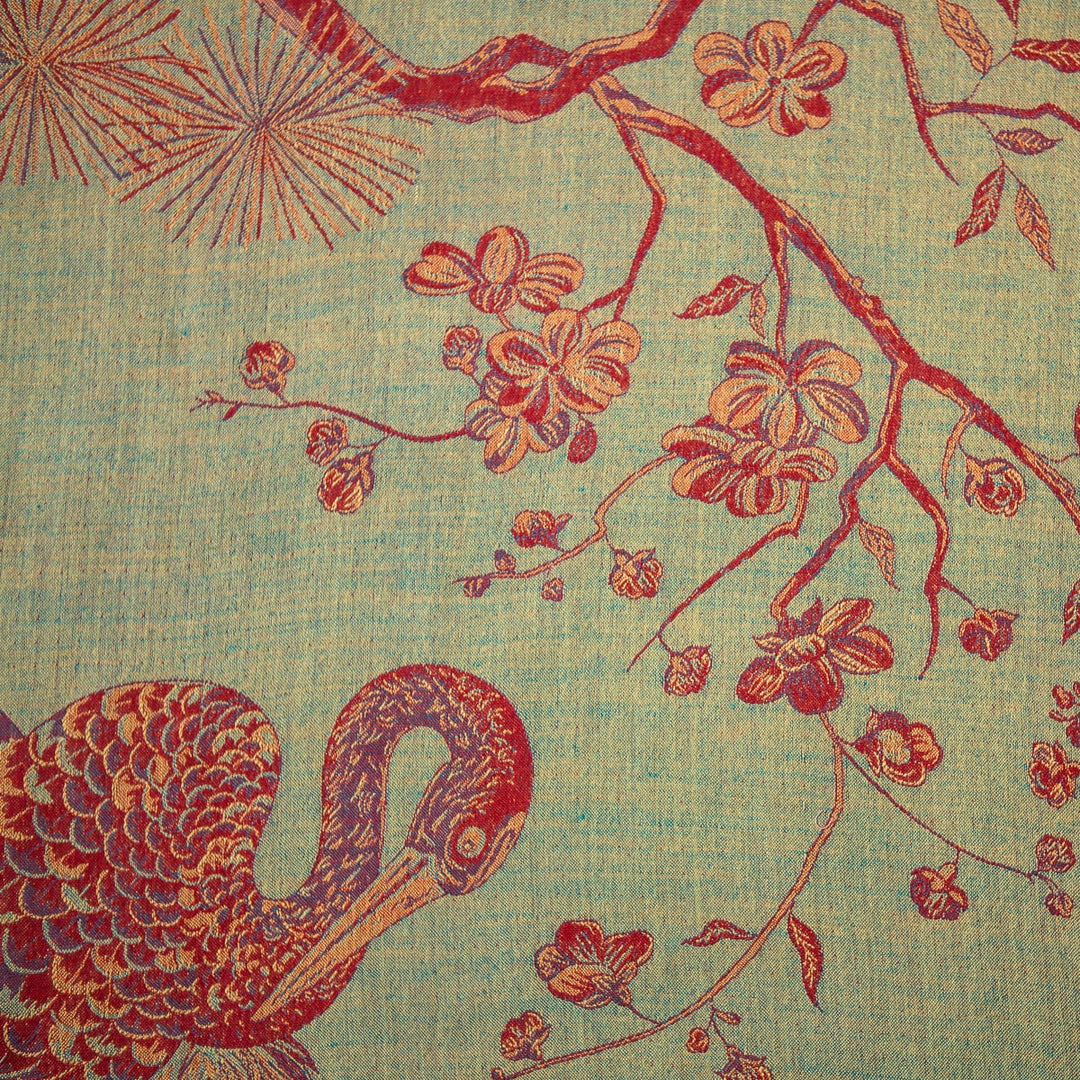 Decorative fabric with red floral and bird pattern on a textured green background