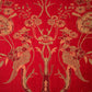 Decorative fabric with floral and leaf patterns on a red background