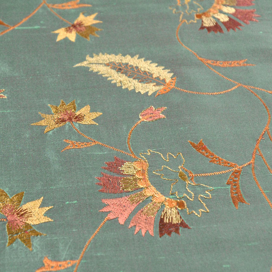 Green silk fabric with embroidered flowers.