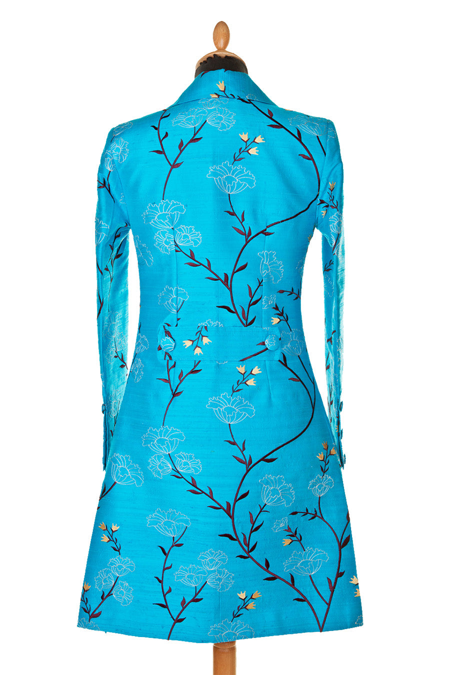 This is the back of a light blue women's coat covered in black floral pattern. Elegant wedding guest coat in turquoise. Mid length wedding coat for over 60s.