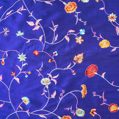 Bright blue fabric with embroidered flowers in many colours