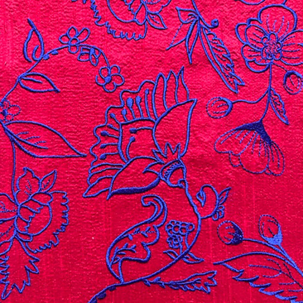bright red vibrant fabric with blue flowers