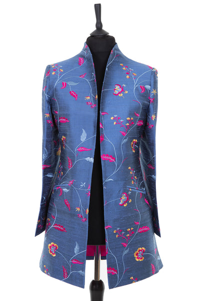 Womens longline jacket, with a soft curved collar in a blue embroidered raw silk with a lighter blue, pink and yellow pattern