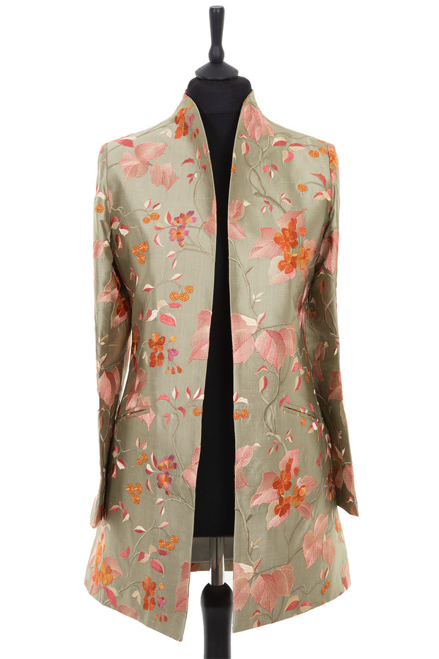 Womens longline jacket with a soft curved collar and slit pockets in a pearlesque soft pale green embroidered silk with soft pink, coral and burnt orange embroidery