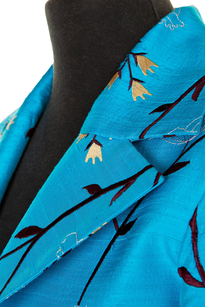 Collar detail of a turquoise women's silk coat. 