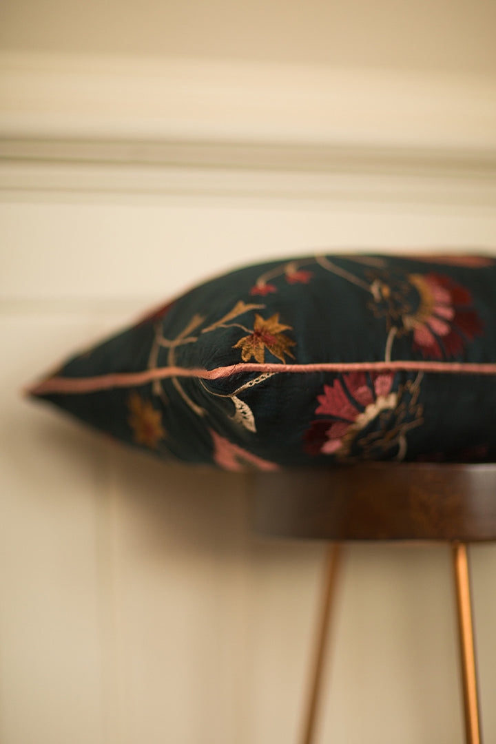 Dark green silk cushion with red flowers. 